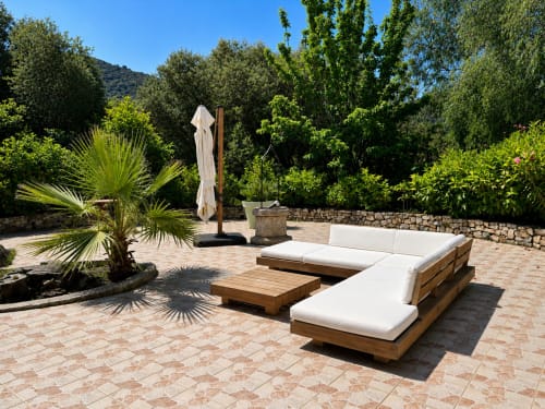 Villa de luxe à L'Île-Rousse avec transats en bois, murs en pierre, palmiers et vue sur les montagnes
