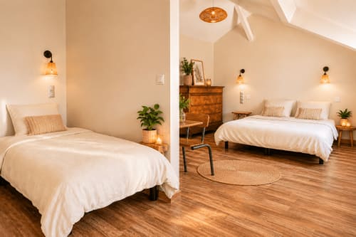 Chambre lumineuse et moderne au gîte Le Clos Divin avec parquet, literie blanche, suspensions et plantes en pot