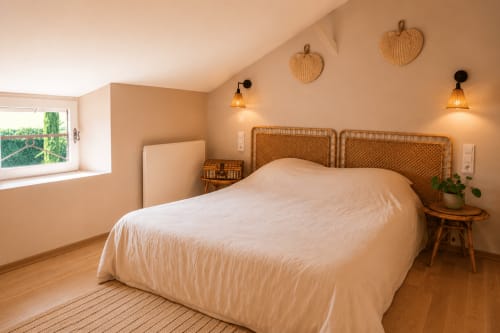 Chambre douillette de la Maison Azur au Clos Divin, Doué-la-Fontaine, avec tête de lit rotin, lumière chaleureuse et vue sur la piscine