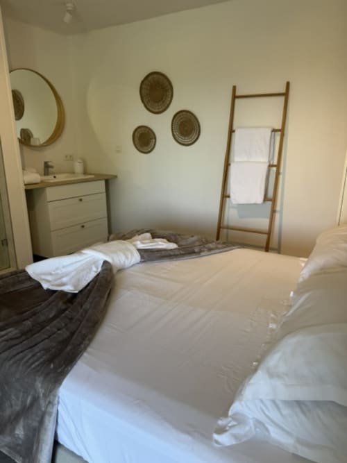 Romarin-kamer in B&B L'arbre Qui Chante met twee eenpersoonsbedden, houten handdoekrek en decoratieve wandmanden te Saint