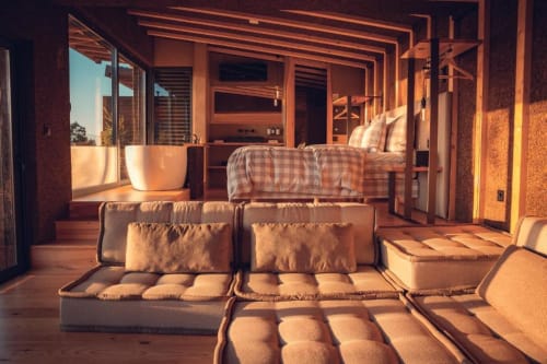 Sunny bedroom lounge at Charm Nature BnB in Azóia, Portugal with plush seating and bed overlooking nature