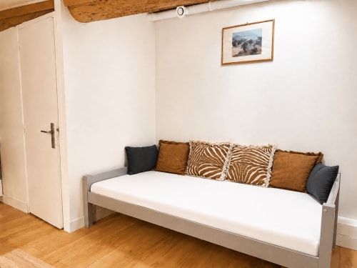 Petit studio lumineux au Petit Rochelois à La Rochelle, avec lit-canapé, coussins décor, poutres bois et cadres muraux