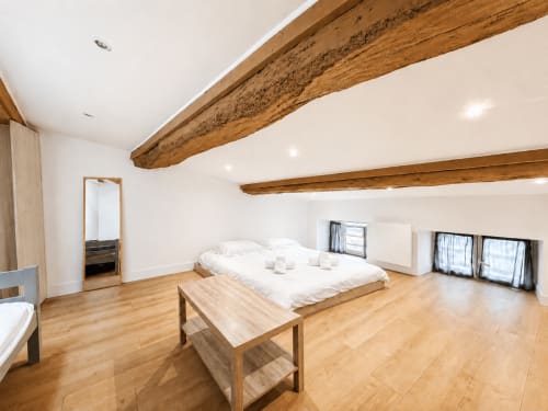 Spacieuse chambre style loft à ARLOÉ à La Rochelle avec poutres apparentes, parquet et équipements modernes