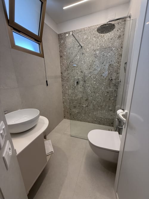 Modern bathroom at Residenza Sant'Antonio with vessel sink, toilet, and walk-in shower with granite walls