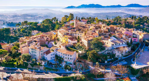 Vue aérienne du village de Spéracèdes avec ses bâtiments colorés, cyprès et montagnes en Provence, France