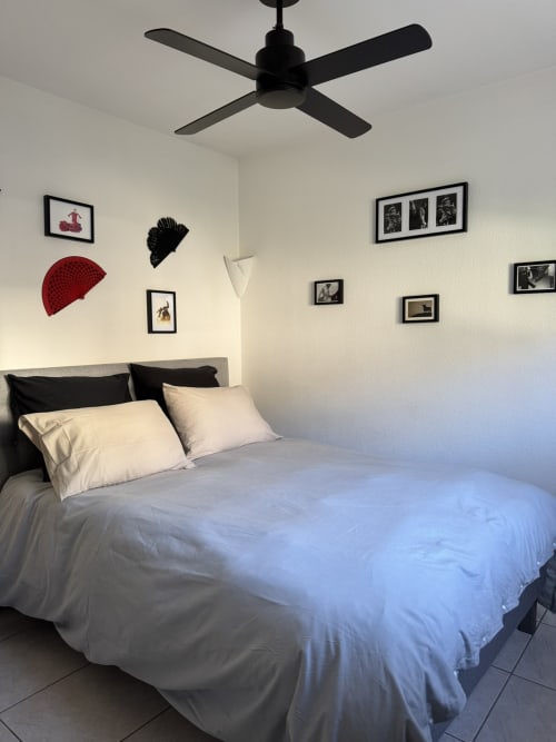 Dormitorio moderno en L'instant D'un Sejour BnB en Le Gua con cama, ventilador de techo y arte mural ecléctico