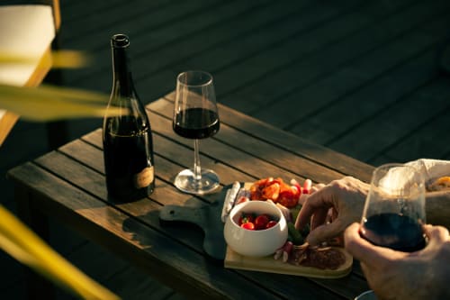 Plateau de vin et charcuterie à La Maison du Potier, Valras-Plage, avec vin rouge, fruits frais et vue côtière
