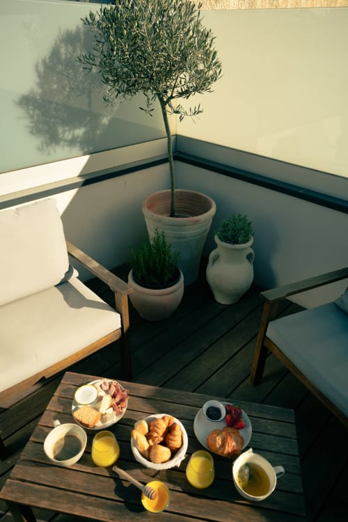 Petit-déjeuner ensoleillé à La Maison du Potier à Valras-Plage : olivier, croissants, jus et ambiance méditerranéenne
