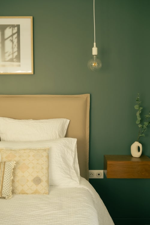 Chambre apaisante à La Maison du Potier à Valras-Plage : murs vert sage, lit capitonné beige et luminaire suspendu