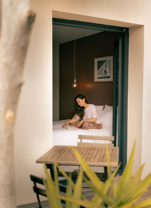 Woman relaxing on bed at La Maison du Potier, a bed and breakfast in Valras-Plage, France