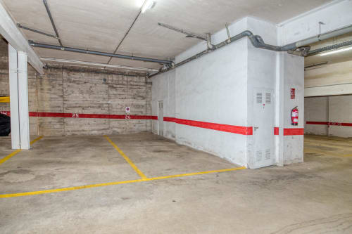Underground parking garage at Finques Garcia Enrich, Palafrugell with numbered spaces and yellow line markings