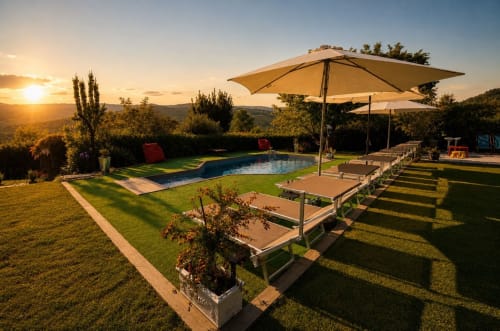 Terrazza con piscina del Gan Eden B&B al tramonto a San Benedetto del Querceto, con lettini e ombrelloni sulla Toscana