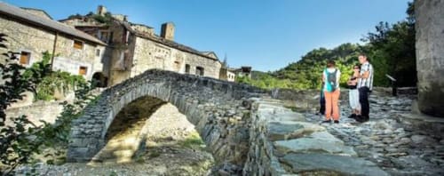 Puente de piedra histórico y edificios en el pueblo pirenaico de Montgat cerca del alquiler vacacional