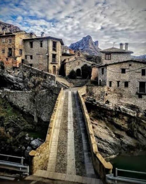 Camino de pueblo medieval de piedra en Montgat Pirineos con vistas a montañas, alojamiento en edificio histórico