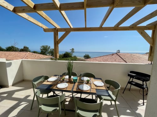 Terrazza sul tetto di Marina di Bravone con zona pranzo, vista sul mare e pergolato in legno a Linguizzetta