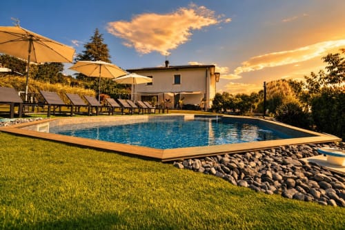 Piscina del B&B Gan Eden al tramonto con lettini, ombrelloni e villa toscana a San Benedetto del Querceto, Italia