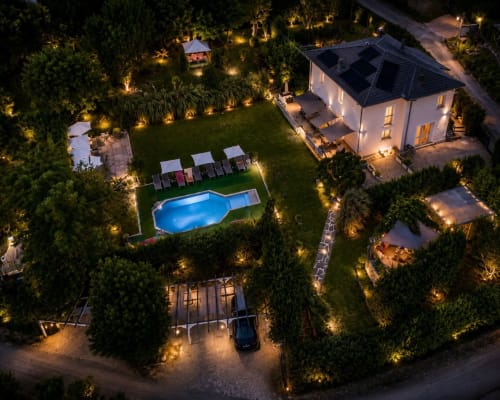 Gan Eden B&B di notte a San Benedetto del Querceto con piscina illuminata, prato curato e villa bianca