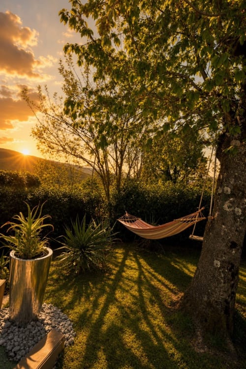Giardino al tramonto della Gan Eden B&B a San Benedetto del Querceto con amaca, piante in vaso e vista sulle montagne