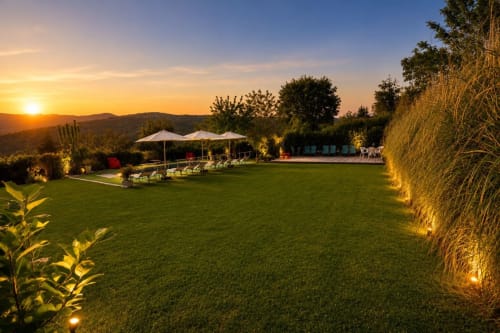 Tramonto nel giardino del B&B Gan Eden a San Benedetto del Querceto con lettini, ombrelloni e prato verde