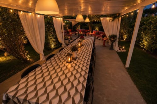 Elegante cena esterna alla Gan Eden B&B con tovaglie decorate, luci sospese e tende drappegiate a San Benedetto