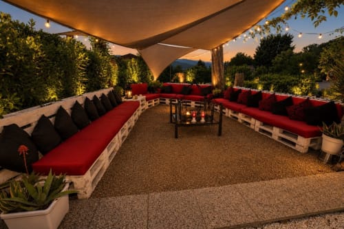 La terrazza serale di Gan Eden a San Benedetto del Querceto con sedute rosse, illuminazione calda e vista sulle montagne