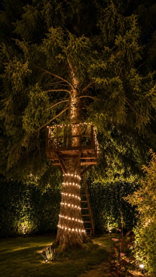 Casa sull'albero illuminata al Gan Eden B&B a San Benedetto del Querceto con luci scintillanti avvolte attorno alla struttura in legno