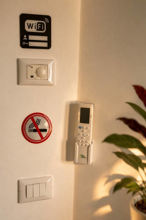 Credenziali WiFi, telecomando AC, termostato, cartello vietato fumare e interruttori luce presso Gan Eden B&B, San Benedetto del Querceto