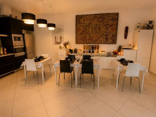 Zona pranzo Gan Eden B&B con cucina moderna, sedie bianche e nere, luci a sospensione, San Benedetto del Querceto