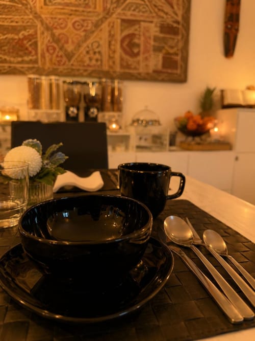 Tavola elegante al Gan Eden B&B a San Benedetto del Querceto con stoviglie nere, cucchiai e fiori bianchi