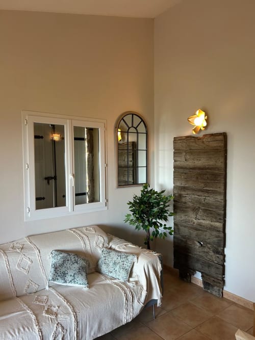 Salon lumineux de Vista D'oro, Monacia d'Aullène, avec canapé crème, fenêtre cintrée, décoration murale en bois et dorures