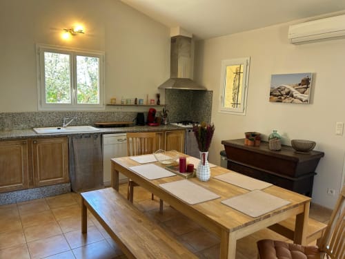 Cuisine-séjour moderne à Vista D'oro avec table en bois, électroménagers en acier inoxydable et comptoirs en granit à Monacia