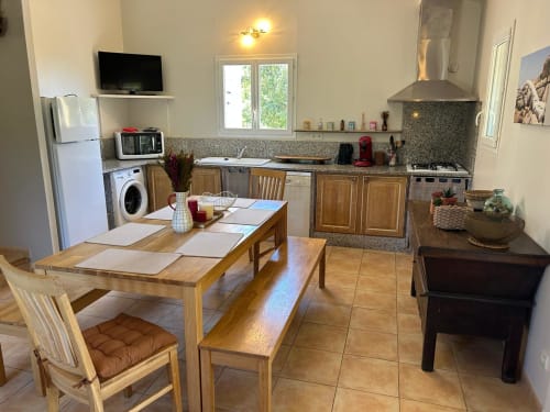 Cuisine-salle à manger moderne à Vista D'oro avec table en bois, électroménagers et comptoirs en granit à Monacia d'Aullène