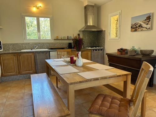 Cuisine et salle à manger Vista D'oro avec table en bois, appareils modernes et baies vitrées avec vue mer à Monacia d'Aullène