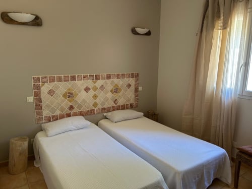 Lits jumeaux avec tête de lit en carrelage décoratif à l'hôtel Vista D'oro, Monacia d'Aullène, Corse