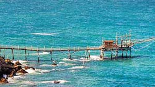 Wooden pier extending into turquoise sea at Pescara INN, Francavilla al Mare, Italy with sea view apartment access