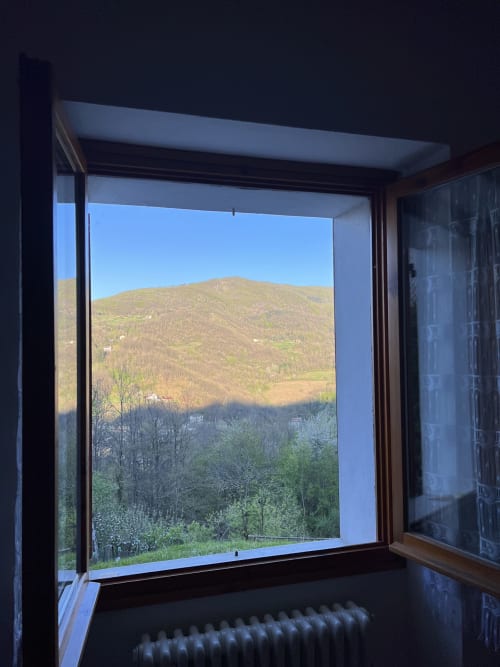 Vista montagna dalla finestra dell'appartamento di R&B La Villa, San Benedetto Val di Sambro, con colline boscose e paesaggio vallivo