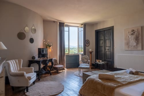Suite élégante à La vie de château à Grignan avec vue sur les montagnes, mobilier crème et décor d'époque
