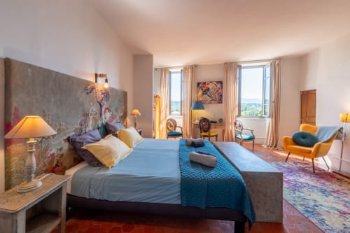 Chambre familiale luxueuse à La Vie de Château avec vue sur les montagnes, literie bleue et mobilier moderne à Grignan