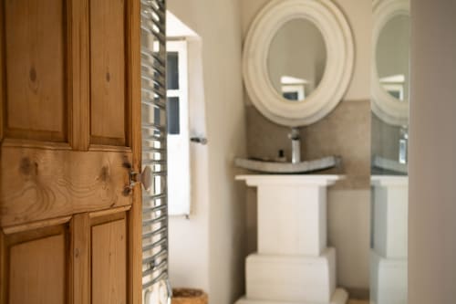 Salle de bain moderne de La Belle au Bois à La vie de château B&B à Grignan, avec lavabo sur piédestal et miroir rond