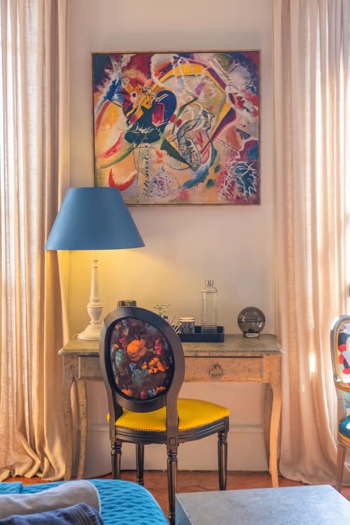 Élégante chambre-bureau avec lampe bleue, fauteuil fleuri et art abstrait vibrant à La vie de château à Grignan