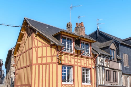 Charmants bâtiments à colombages aux façades jaunes et rouges rayées à Honfleur, Les Maisons de Pierre et Valérie