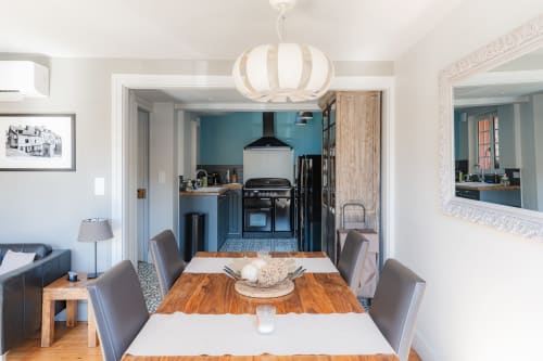 Dining room and kitchen in Honfleur B&B with wooden table, blue accents, and modern appliances
