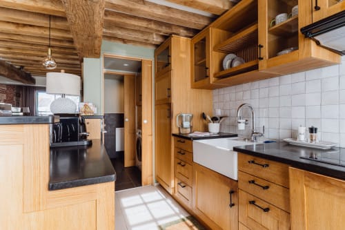 Charming wooden kitchen with farmhouse sink, white tile backsplash, and exposed beams in Honfleur BnB