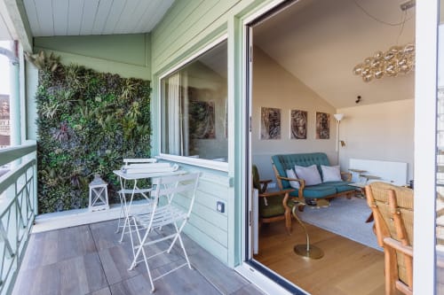 Balcony with green living wall and white seating opening to cozy living room at Les Maisons de Pierre et Valérie, Honfleur