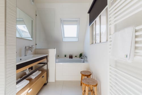 Modern bathroom at Les Maisons de Pierre et Valérie in Honfleur with wooden vanity, skylight, and bathtub