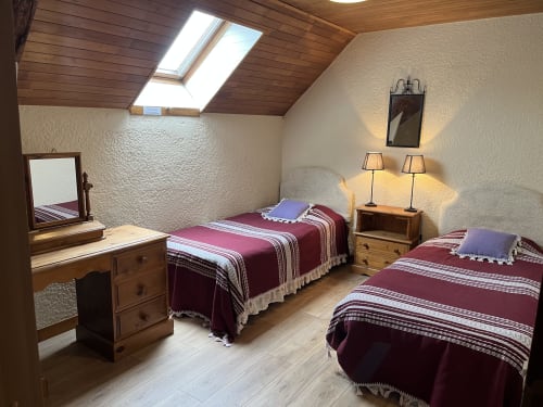 Chambre mansardée au Gîte La Vieille Ferme avec poutres apparentes, lucarne, trois lits jumeaux garnis de parure bordeaux