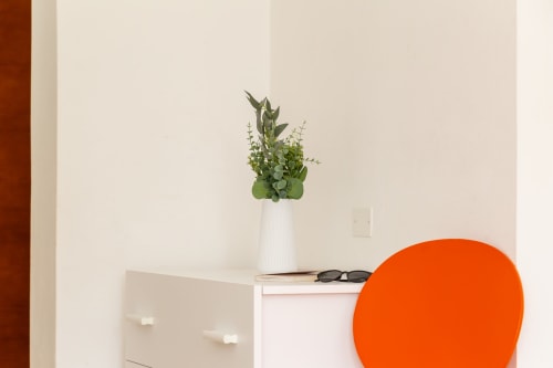 Modern apartment interior at Agriturismo Chiai Francesco with white desk, fresh green plant arrangement, and orange chair