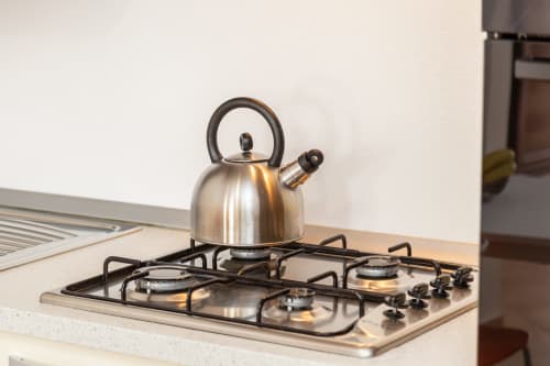 Stainless steel kettle on gas cooktop in kitchen at Agriturismo Chiai Francesco apartment, Bari Sardo