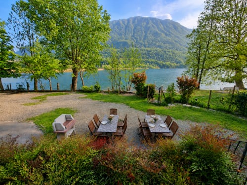 Area ristorazione a bordo lago presso il Villaggio turistico Lago Dorato a Carlazzo con tavoli, vista montagna e acque turchesi