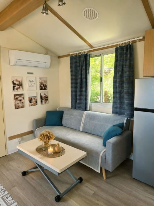 Moderna camera al Lago Dorato BnB a Carlazzo con divano grigio, tende scure e soffitto voltato